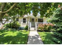 Charming single-story home with a cozy front porch, lovely landscaping, and a well-maintained lawn at 1411 N Kenmore Rd, Indianapolis, IN 46219