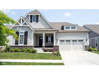 Charming home featuring a well-manicured lawn, a two-car garage, and a welcoming front porch at 1590 Birchfield Dr, Westfield, IN 46074