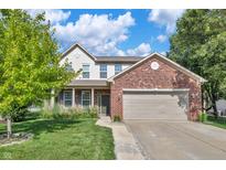 Two-story home featuring a brick facade, attached garage, and a well-maintained lawn with mature landscaping at 2211 Willowview Dr, Indianapolis, IN 46239