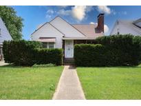 Charming home with mature landscaping, a walkway leading to the front door, and a well-maintained lawn at 2309 Maple St, Columbus, IN 47201