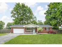 Charming red brick ranch home with a well-manicured lawn and attached two-car garage at 258 N Green Springs Rd, Indianapolis, IN 46214
