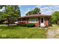 Charming single-story red brick home with a well-manicured lawn and lovely front yard landscaping at 3922 N Irvington Ave, Indianapolis, IN 46226