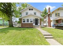Charming two-story home featuring a well-manicured lawn, inviting front porch, and a classic facade at 4002 Guilford Ave, Indianapolis, IN 46205