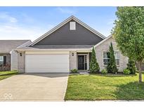 Charming single-story home with brick and gray siding, features a well-maintained lawn and an attached two-car garage at 5409 Brandywine Dr, Whitestown, IN 46075