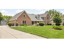 Beautiful two-story brick home featuring a well-manicured lawn and mature landscaping at 5695 N Red Oak Dr, Greenfield, IN 46140