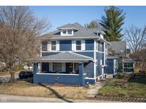 Charming two-story home features a covered front porch, gray roof, and a blue exterior at 6101 Broadway St, Indianapolis, IN 46220