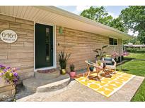 Charming front entrance featuring a seating area and green door at 6464 Whitley Ln, Indianapolis, IN 46260