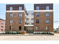 Apartment complex with brick facade, well-maintained landscaping, and street view on a sunny day at 721 E North St # 2C, Indianapolis, IN 46202