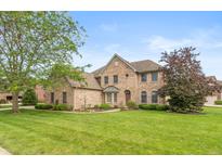 Brick two story home featuring a well-manicured lawn and mature landscaping at 725 Ridge Gate Dr, Brownsburg, IN 46112