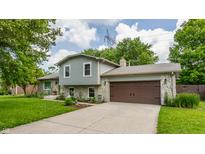 Charming two-story home featuring a stone facade, attached two-car garage, and well-maintained landscaping at 8015 Ridgegate East Dr, Indianapolis, IN 46268