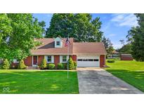 Charming brick ranch home with a well-manicured lawn and an American flag at 1010 Maple St, Greenwood, IN 46142