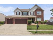 A lovely two-story home with a brick facade and a well-manicured lawn and a three car garage at 10312 Gladeview Dr, Indianapolis, IN 46239