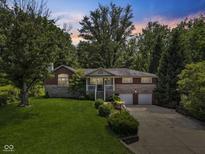 Charming two-story home with a lush green lawn and manicured landscaping at 11603 Maze Rd, Indianapolis, IN 46259