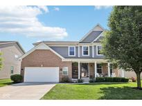 Charming two-story home featuring a brick facade, attached two car garage, and inviting front porch at 123 Bentree Blvd, Danville, IN 46122