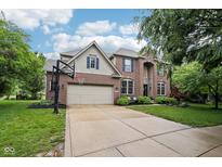 Charming brick two-story home featuring a large driveway and attached two-car garage at 1345 Lewiston Dr, Westfield, IN 46074