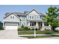 Charming two-story home with covered porch, manicured lawn and inviting curb appeal at 14982 Dawnhaven Dr, Westfield, IN 46074