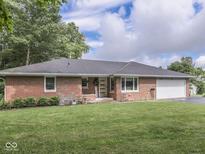Charming brick ranch home featuring a well-manicured lawn and attached one car garage at 1504 Mcclure Rd, Columbus, IN 47201