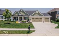 Charming home with a three-car garage, well-manicured lawn, and inviting front porch at 15879 Viking Commander Way, Westfield, IN 46074