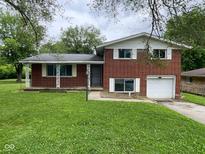Classic red brick two-story home features an attached garage and spacious front yard at 1749 N Graham Ave, Indianapolis, IN 46218