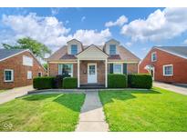Charming brick home featuring a manicured lawn, tidy bushes, and a sidewalk leading to the front door at 2908 Sherman St, Anderson, IN 46016