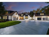 Stunning home exterior featuring a circular driveway and three-car garage with modern black-and-white Tudor style at 3549 W 131St St, Carmel, IN 46032