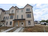 Newly constructed two-story townhome showcasing modern farmhouse style with neutral siding and black trim at 4141 Barrel Ln, Westfield, IN 46062