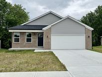 View of the exterior of the house with an attached garage at 5 Watson Dr, Trafalgar, IN 46181
