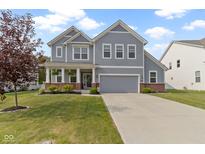 Charming two-story home with gray siding, a well-manicured lawn, and an attached two-car garage at 6107 Flagler Ln, Brownsburg, IN 46112