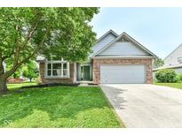 Charming brick and siding home with a well-manicured lawn and a two-car garage at 7168 Camwell Dr, Indianapolis, IN 46268