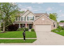 Charming two-story home boasts lush landscaping, a brick facade, and an attached two-car garage at 7193 Wythe Dr, Noblesville, IN 46062