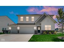 Charming two-story home featuring a three-car garage, well-manicured lawn, and stylish architectural details at 8690 Lester Pl, Pendleton, IN 46064