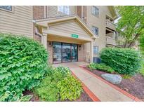 Inviting building entrance with manicured landscaping and clearly marked address at 8720 Yardley Ct # 207, Indianapolis, IN 46268