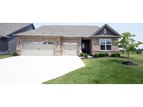 Charming brick home boasts a well-manicured lawn, two-car garage, and inviting front entrance at 9671 Holborn Ave, McCordsville, IN 46055