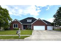 Charming brick home with a well-manicured lawn, a two-car garage and a welcoming front yard at 1019 White Oak Dr, Plainfield, IN 46168