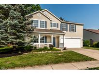 Charming two-story home with blue shutters, a well-manicured lawn, and an attached two-car garage at 10216 Hatherley Way, Fishers, IN 46037