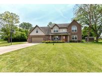 Charming two-story brick home with manicured lawn and basketball hoop on driveway at 1031 W Morning Walk Dr, Greenfield, IN 46140