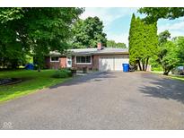 Charming single-story brick home with a spacious driveway and mature trees in a serene neighborhood at 11522 Newport Dr, Indianapolis, IN 46236