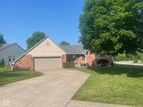 Charming single-Gathering home featuring a brick facade, well-manicured lawn, and a concrete driveway leading to the garage at 1165 Tewksbury Ct, Mooresville, IN 46158