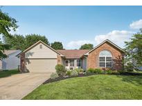 Charming single-story home with a manicured lawn, brick accents, and an attached two-car garage at 12848 Patrick Ct, Fishers, IN 46038