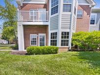 Brick condo building with a balcony, green lawn, and manicured landscaping at 1359 Shadow Ridge Rd, Indianapolis, IN 46280
