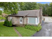Charming stone-clad home with well-manicured lawn and a classic chimney at 1631 S Post Rd, Indianapolis, IN 46239