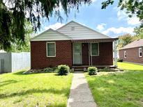 Charming brick home with a well-maintained lawn and inviting entrance at 1908 S Biltmore Ave, Muncie, IN 47302
