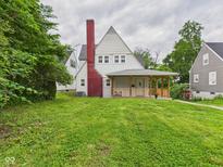 Charming home with a red brick chimney, covered porch, and well-maintained lawn at 1910 W 10Th St, Anderson, IN 46016
