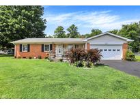 Charming brick home with a well-manicured lawn, flowerbeds, and an attached two-car garage at 2608 E 500 N, Whiteland, IN 46184