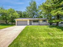Charming single-story home featuring a well-maintained lawn, mature trees, and an attached two-car garage at 3344 Southwest Dr, Indianapolis, IN 46241