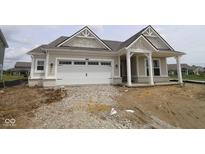 New home features a two-car garage, covered front porch, beige siding, white trim, and gabled roof with architectural details at 3824 Dutton Dr, Bargersville, IN 46106