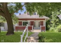 Inviting red two-story home with a classic craftsman architectural style, front porch, and well-maintained lawn at 4226 Cornelius Ave, Indianapolis, IN 46208