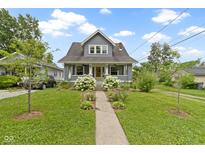 Charming home with a well-manicured lawn and beautiful hydrangea bushes lining the walkway at 4813 E 11Th St, Indianapolis, IN 46201