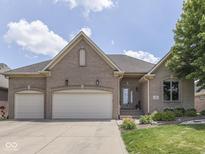 Charming brick home featuring a three-car garage, manicured lawn, and a welcoming front entrance at 6525 Carolina Blvd, Indianapolis, IN 46217