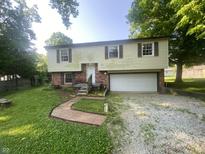 Two story home featuring brick accents, an attached garage, and a pathway to the front door at 667 E Edgewood Ave, Indianapolis, IN 46227